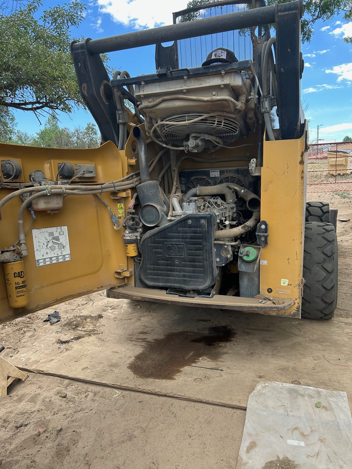 CAT 262C skid steer with the rear opened up, exposing the diesel engine and hydraulic filters