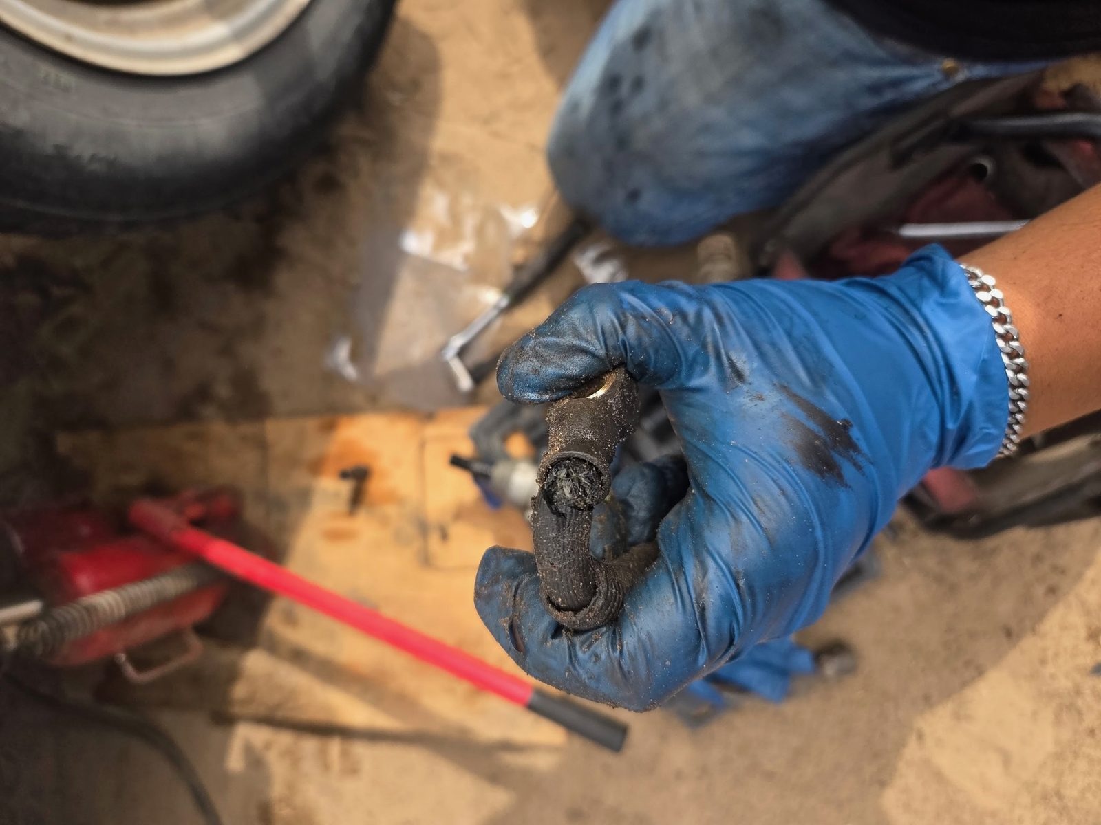 Technician holding a worn engine mount pulled during an on-site repair
